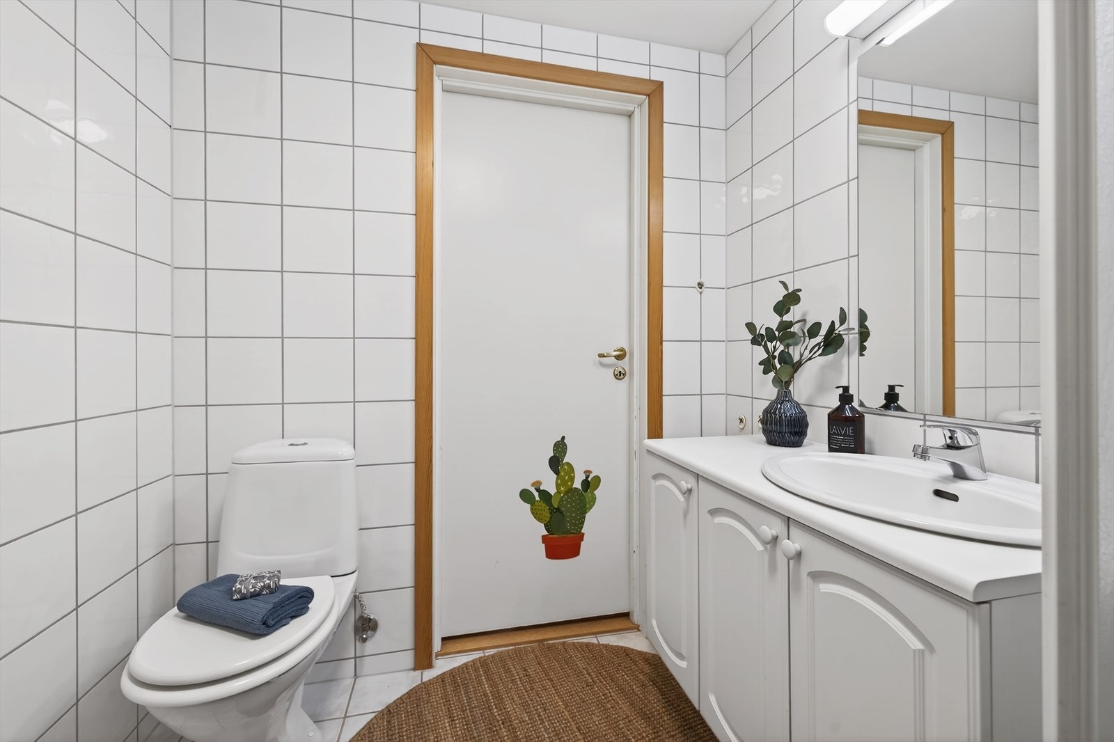Klassisk hvit baderomsinnredning med speil og lys over Galleribilde