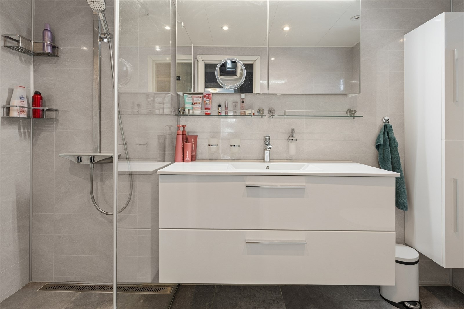 Badet utstyrt med god skapplass og bred servantinnredning med skuffeseksjon. Galleribilde