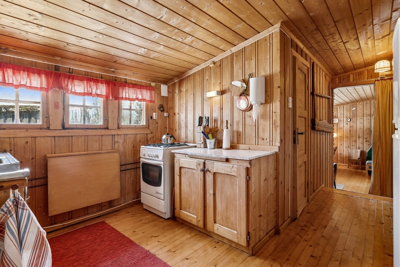 Her finner du også oppvaskbenk med stålbeslag og kum, samt en frittstående gasskomfyr for enkel matlaging. Galleribilde