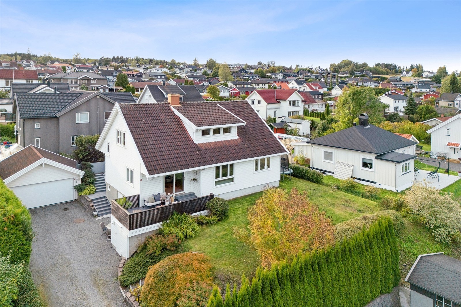 Eiendommen har dobbelgarasje, pent opparbeidet hage og flere uteplasser. Galleribilde