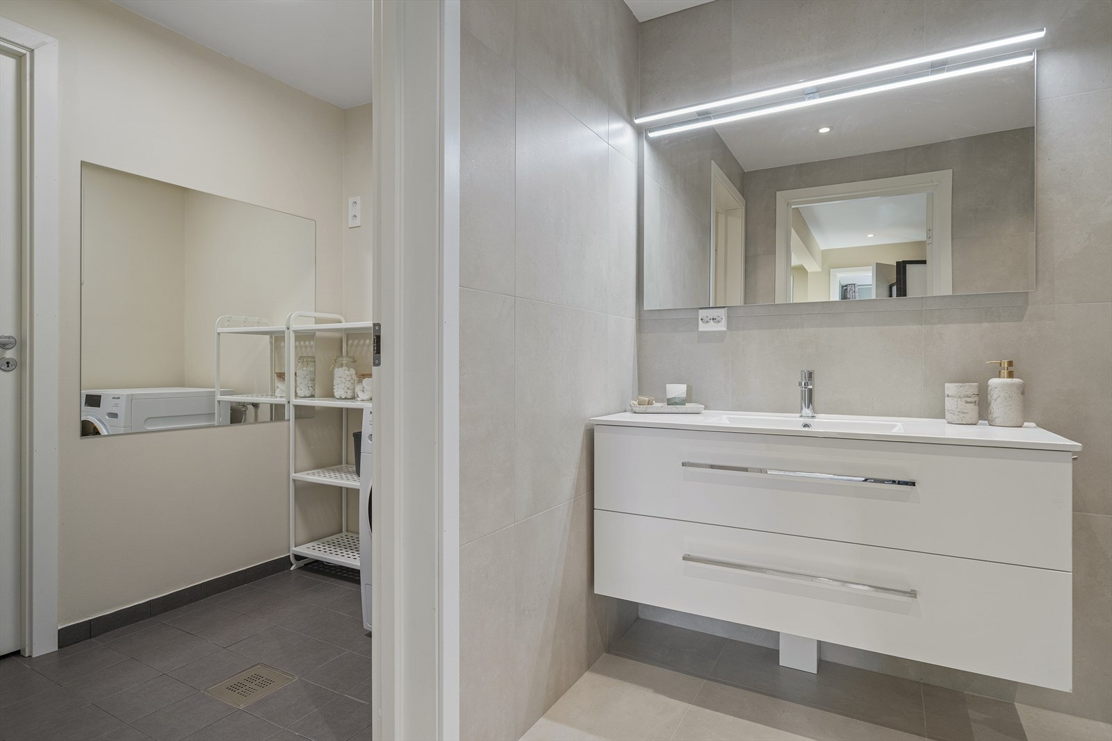 Innenfor badet finner du vaskerom og bod - Vaskerommet har flislagt gulv med sluk og opplegg for vaskemaskin Galleribilde