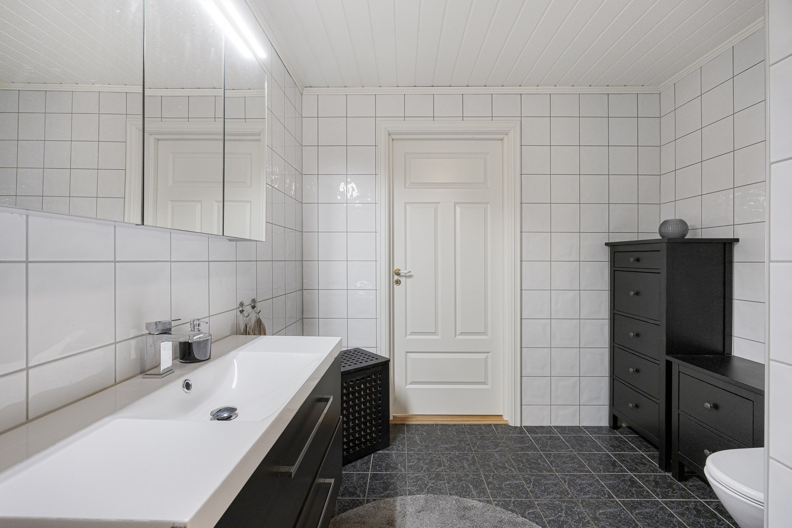 Heldekkende servant over servantskap med glatte, folierte fronter. Varmtvannsberederen på 194 liter fra 2008 er plassert på badet. Galleribilde