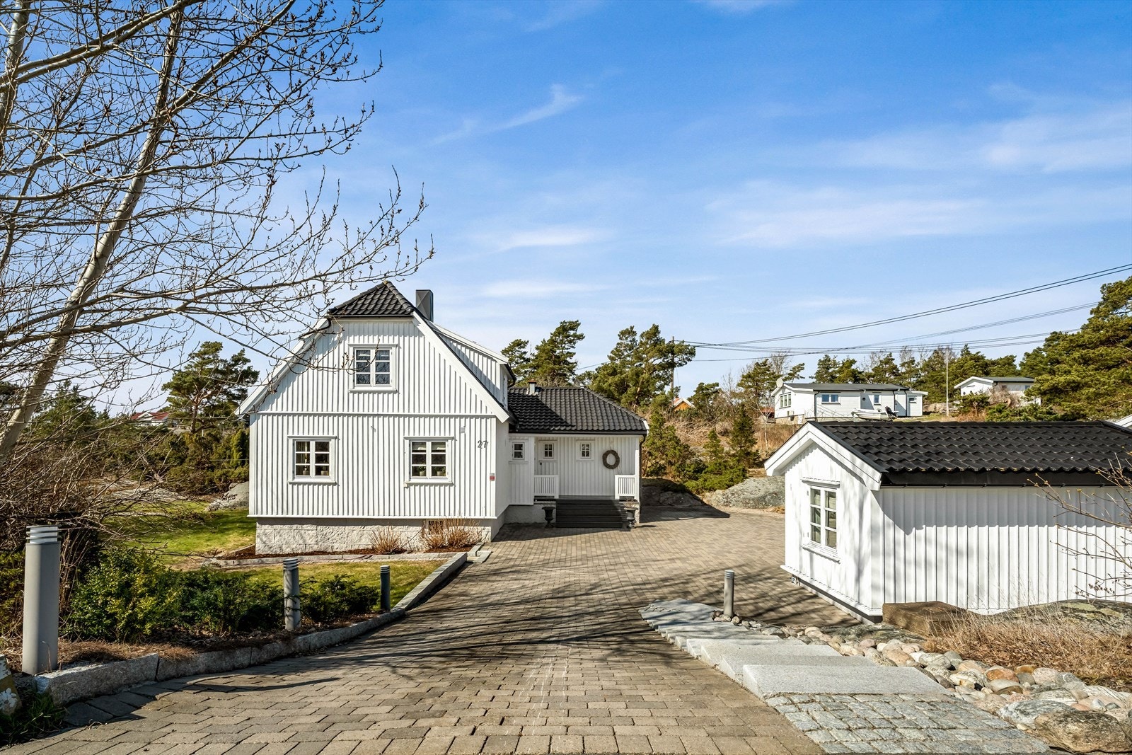 Eiendommen sett fra innkjørselen, med hovedhus og det frittstående annekset. Galleribilde