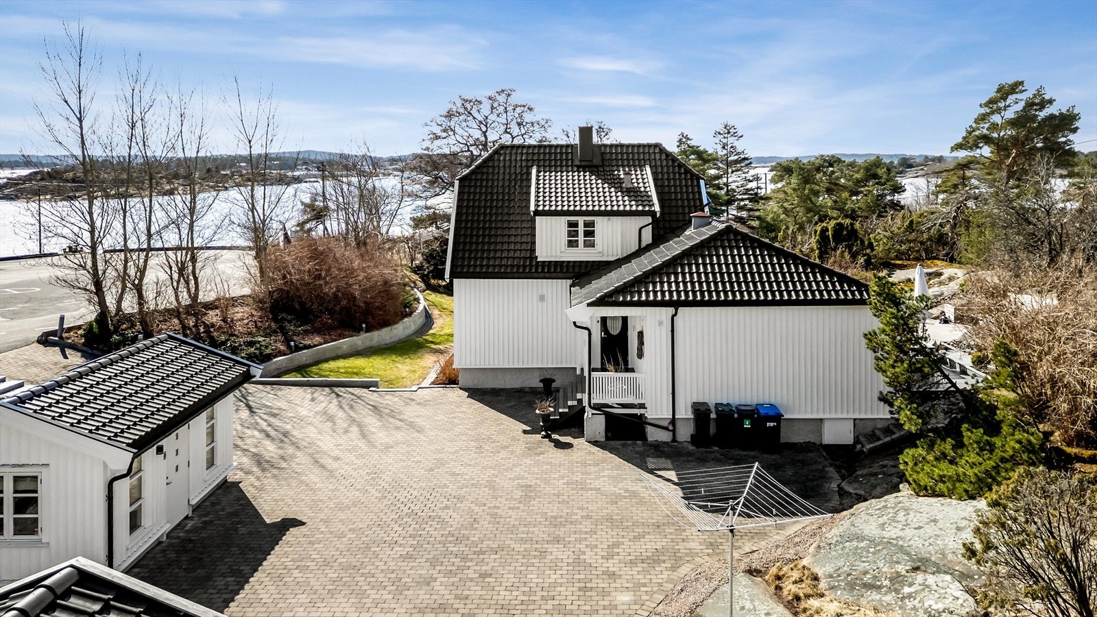 Oversikt over den steinbelagte gårdsplassen, hovedhuset og annekset. Galleribilde