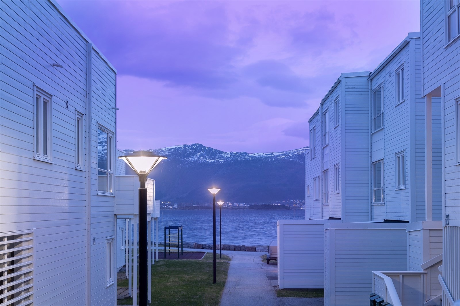 Fra leilighetens uteområde og stue er dette utsikten man kan nyte. Mellom rekkehusene ser man både havet og mot Sulafjellet. Galleribilde
