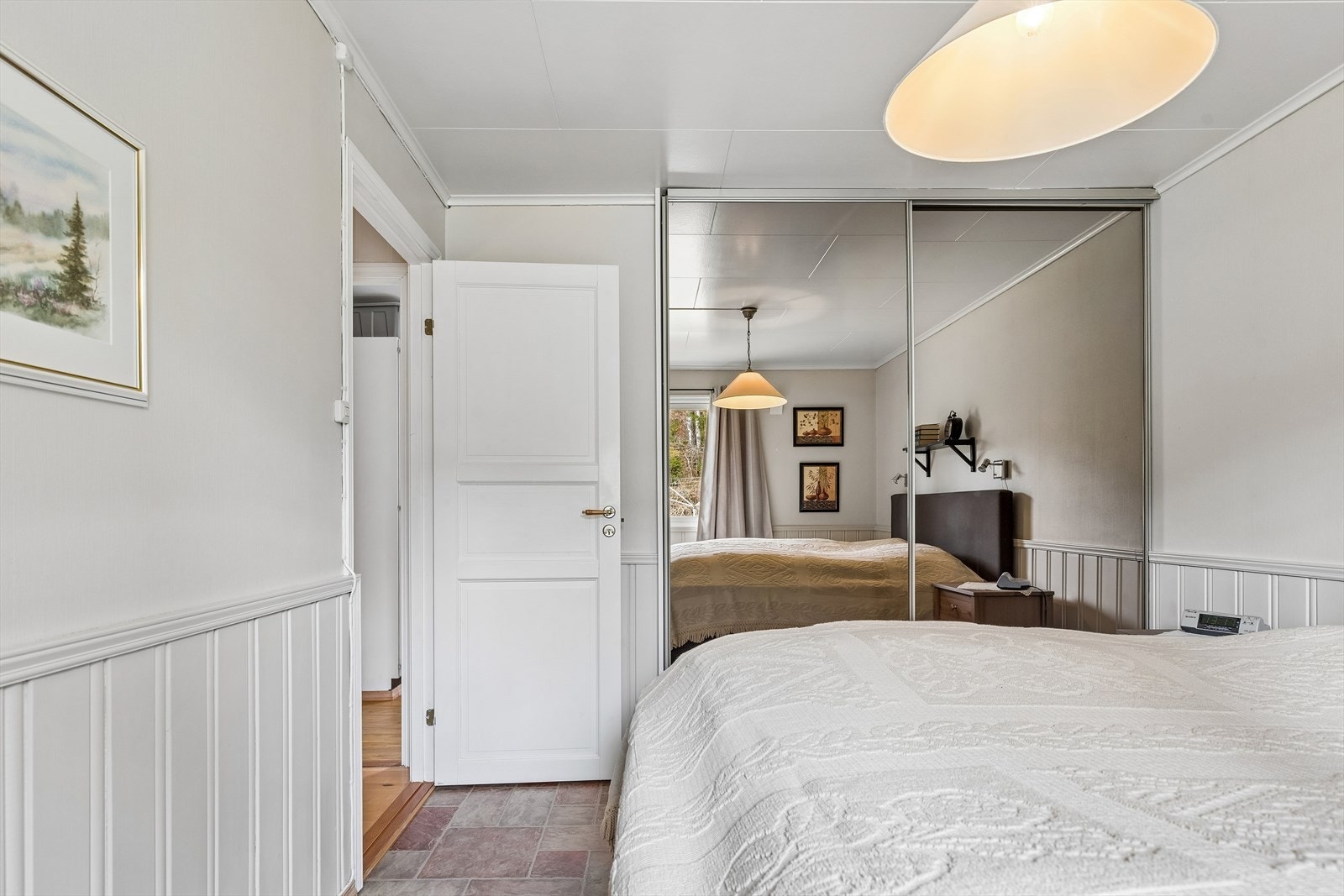 En plassbygget skyvedørsgarderobe sørger for praktisk oppbevaring. Galleribilde