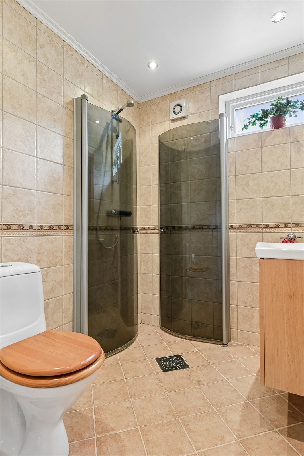 Badet nede er helfliset i delikate beigenyanser og har gulvmontert toalett, dusjhjørne med innfellbare dører og lun gulvvarme. Galleribilde