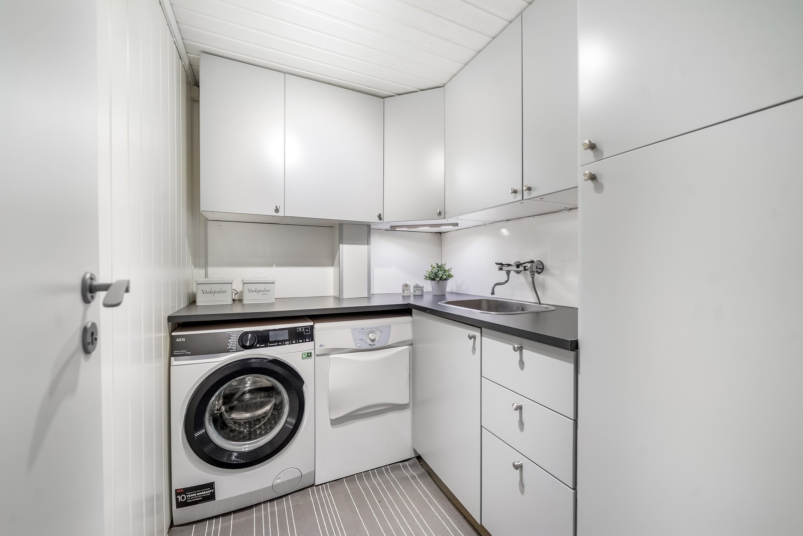 Eget vaskerom med opplegg for vaskemaskin og tørketrommel, samt god plass til oppbevaring og kleshåndtering. Galleribilde