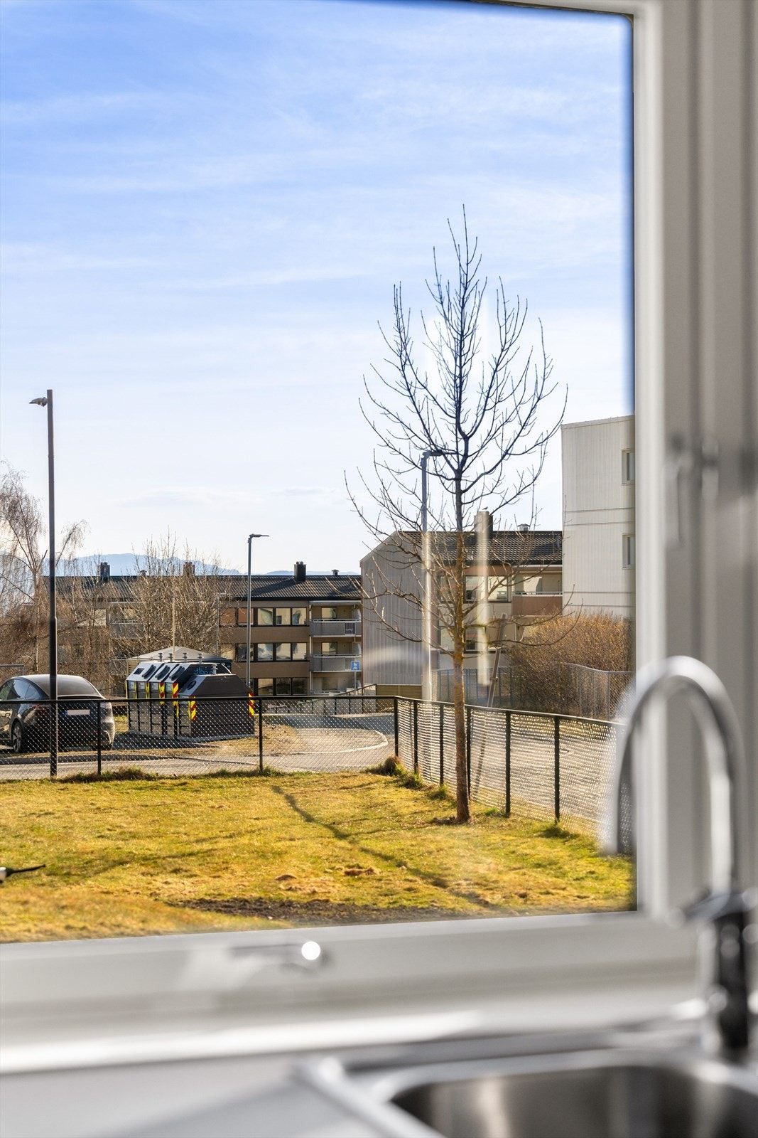 Fra kjøkkenet har man hyggelig utsyn mot sameiets fellesområder. Galleribilde