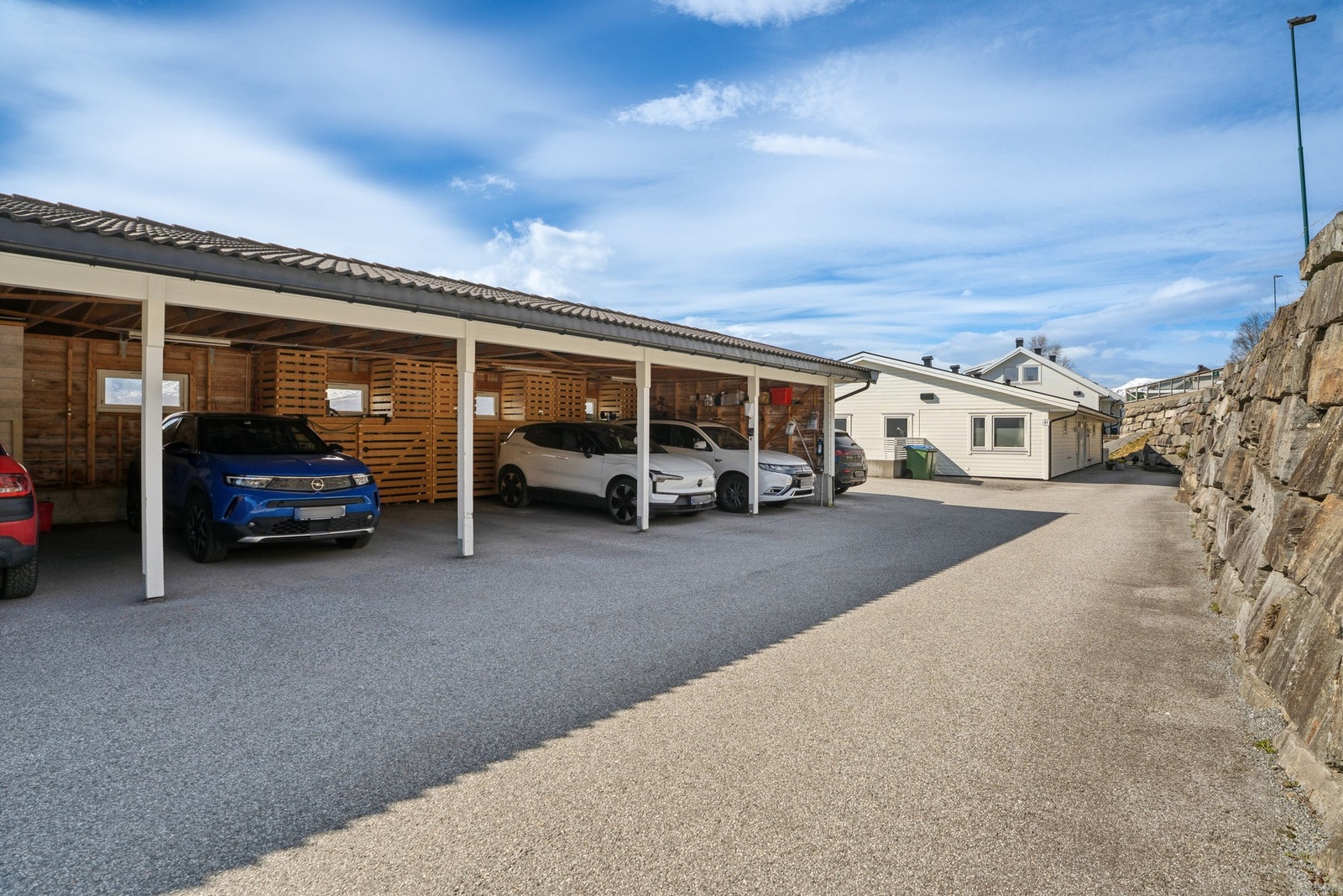Boligen disponerer egen biloppstillingsplass i carport Galleribilde