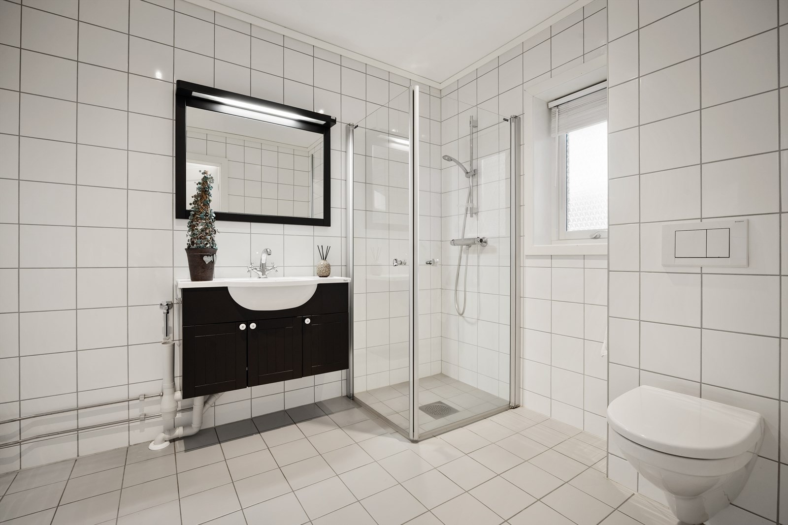 Romslig bad med flislagte overflater, gulvvarme, downlights og opplegg for vaskemaskin. Galleribilde