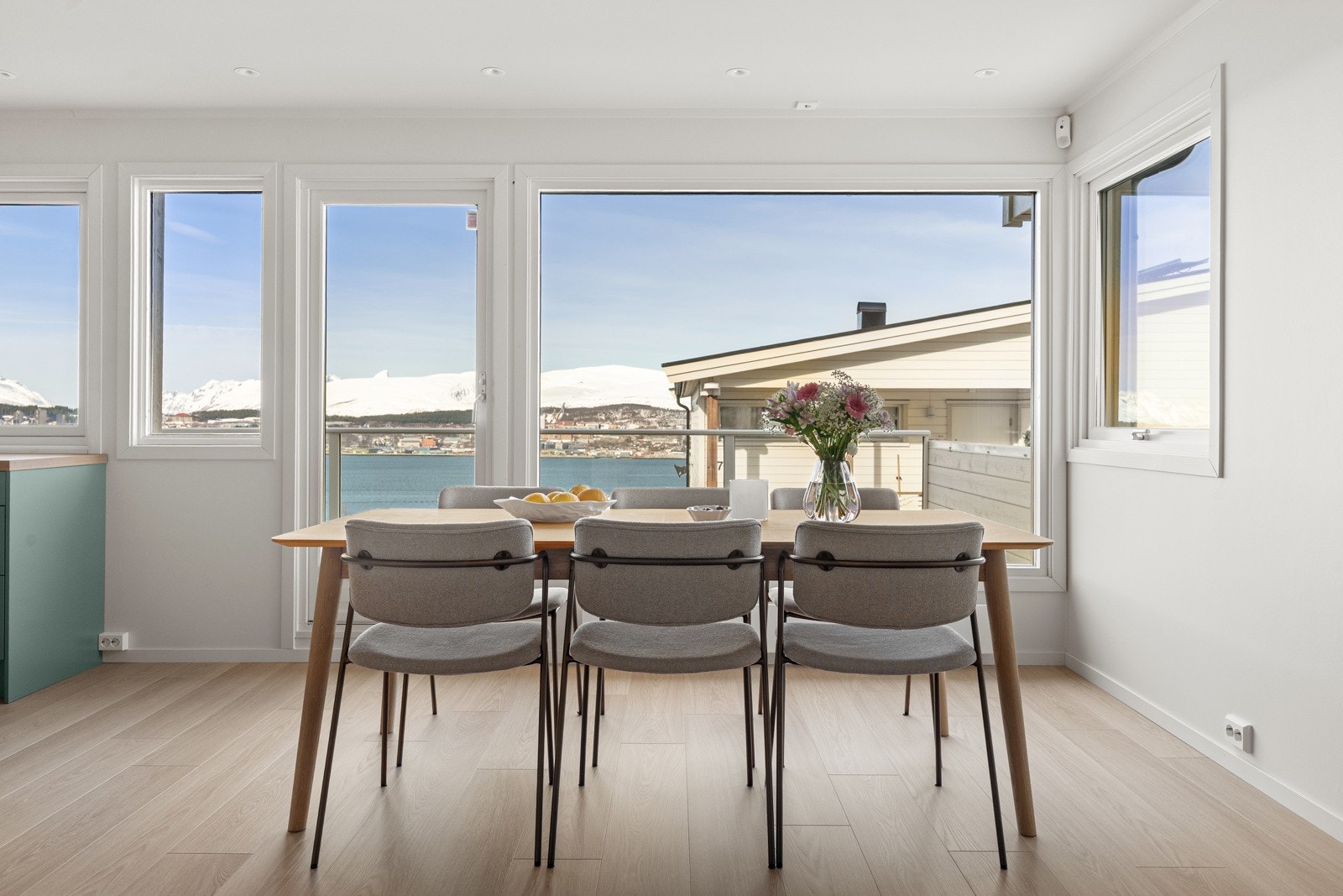 De store vindusflatene sikrer godt med innslipp av naturlig lys. Spisebordet har sin naturlige plass ved kjøkkenet.