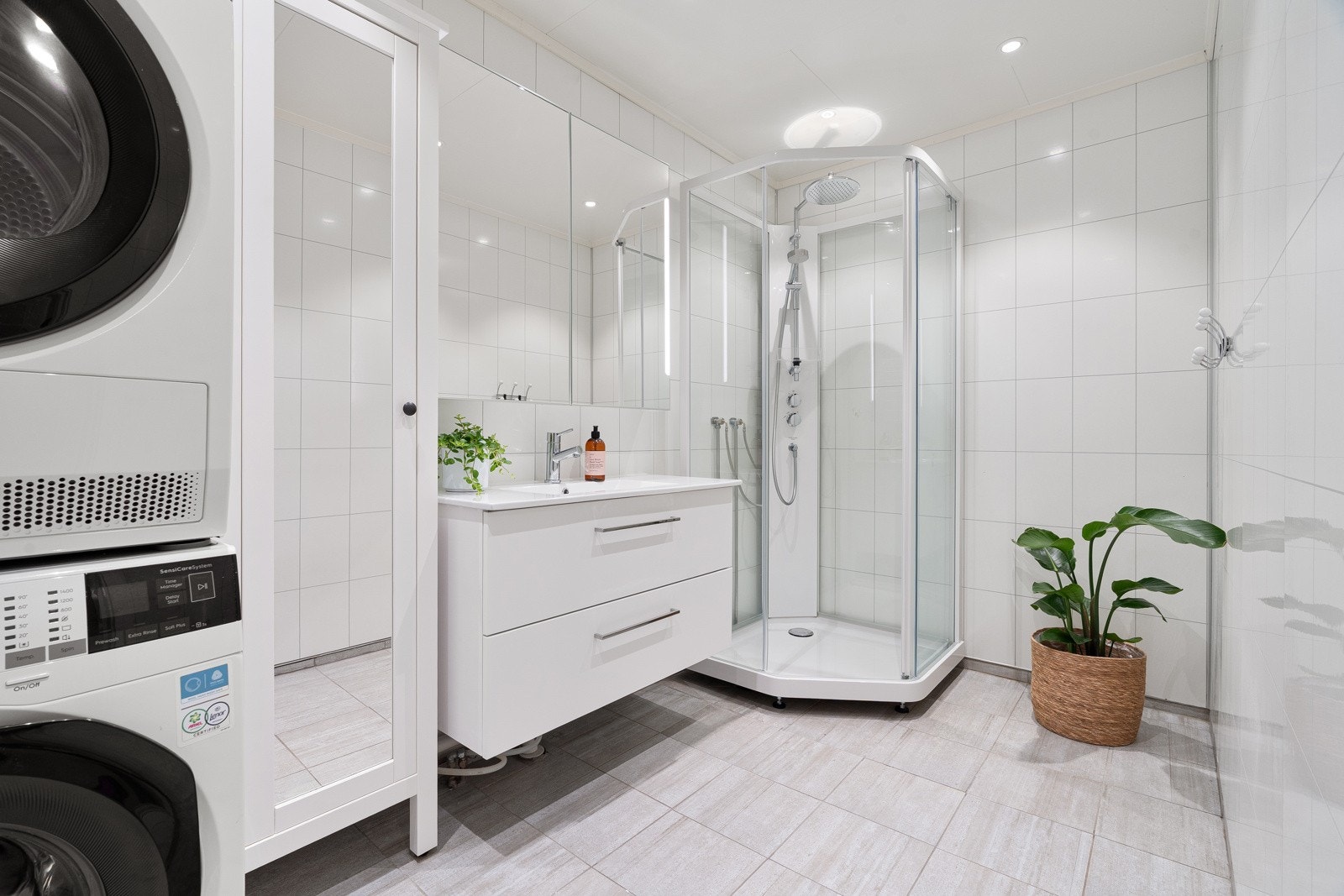 Badet framstår romslig, og er utstyrt med dusjkabinett opplegg for vaskemaskin og tørketrommel, samt baderomsinnredning med mye oppbevaringsplass.