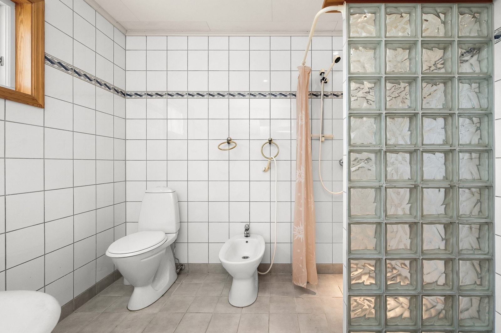 Badet har en praktisk planløsning med separat dusjsone, glassbyggerstein og god plass. Galleribilde