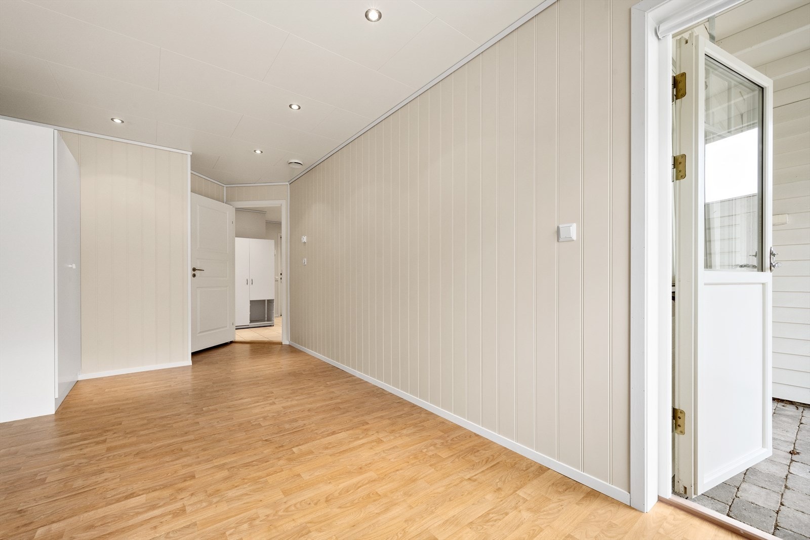 Fra soverommet er det utgang til uteplass med belegningsstein og hage. Galleribilde