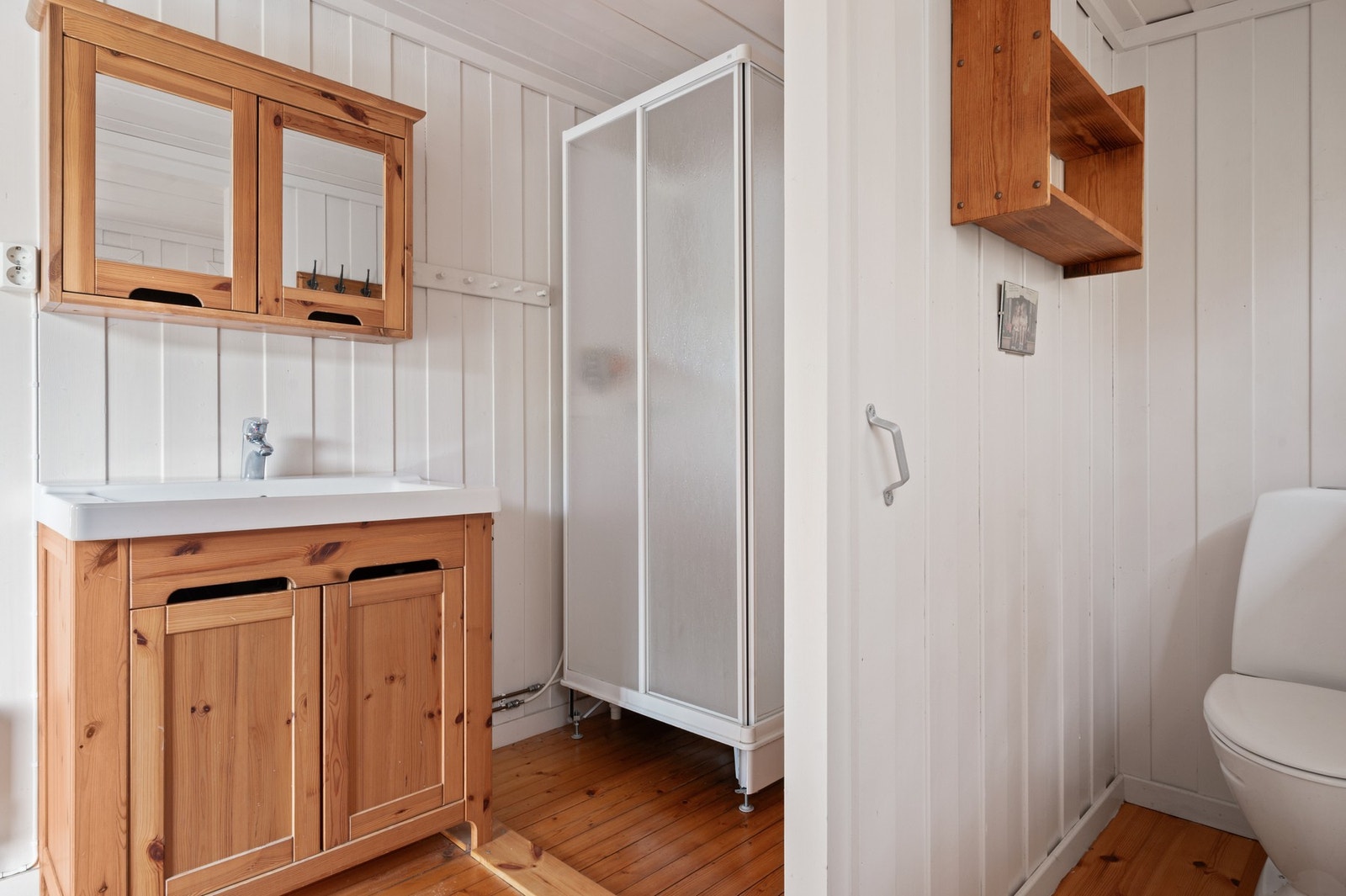 Badet er plassert i eget rom utenfor hytta og er utstyrt med dusjkabinett, toalett og servant med underskap. Sommervann Galleribilde