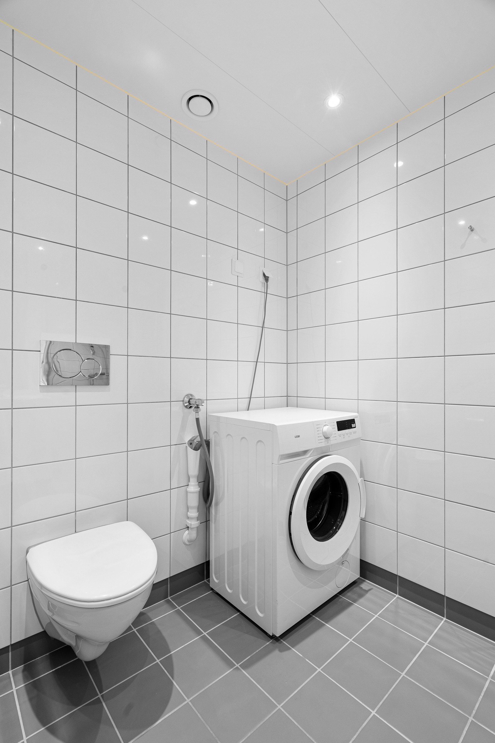 Lyst bad med flisbelagte vegger og gulv.