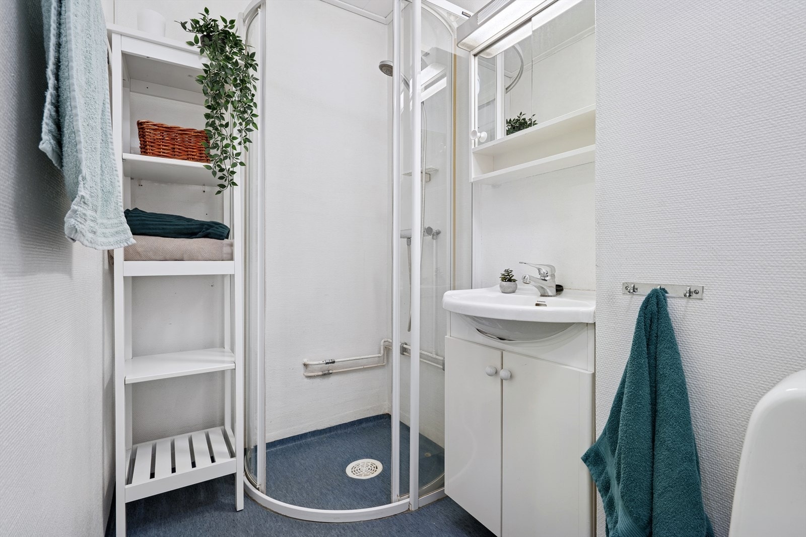 Badet er innredet med dusjhjørne, servant og toalett. Galleribilde