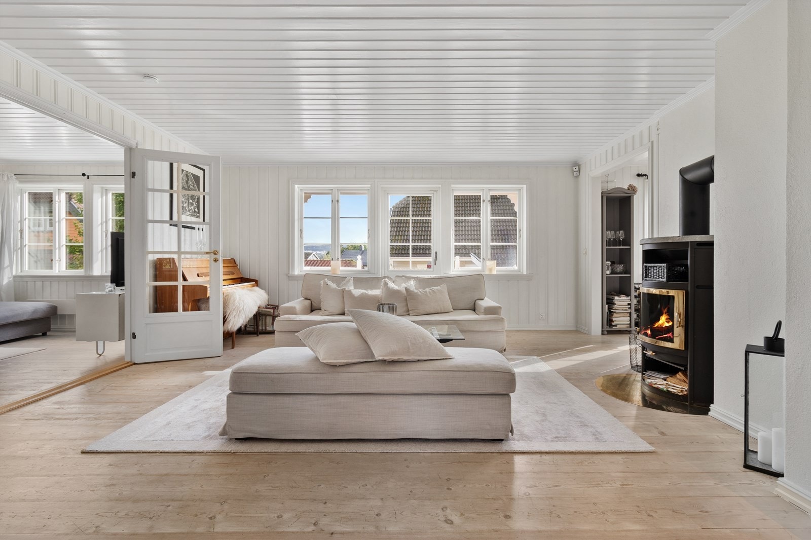Stuen er lys og tiltalende med store vindusflater og moderne peisovn. Galleribilde