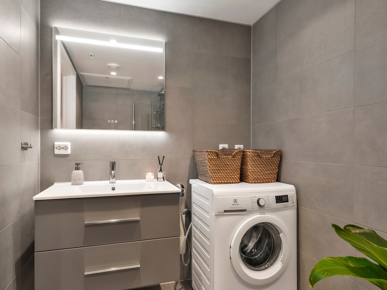Badet er utstyrt med servant, vegghengt toalett, dusjnisje og opplegg for vaskemaskin. Galleribilde