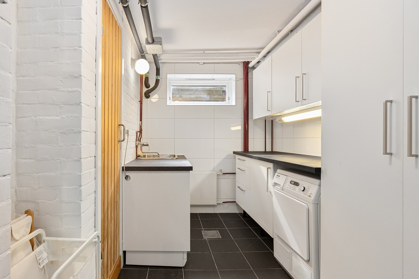 Praktisk vaskerom oppgradert i 2016, med skapinnredning, rustfritt skyllekar og opplegg for vaskemaskin. Galleribilde