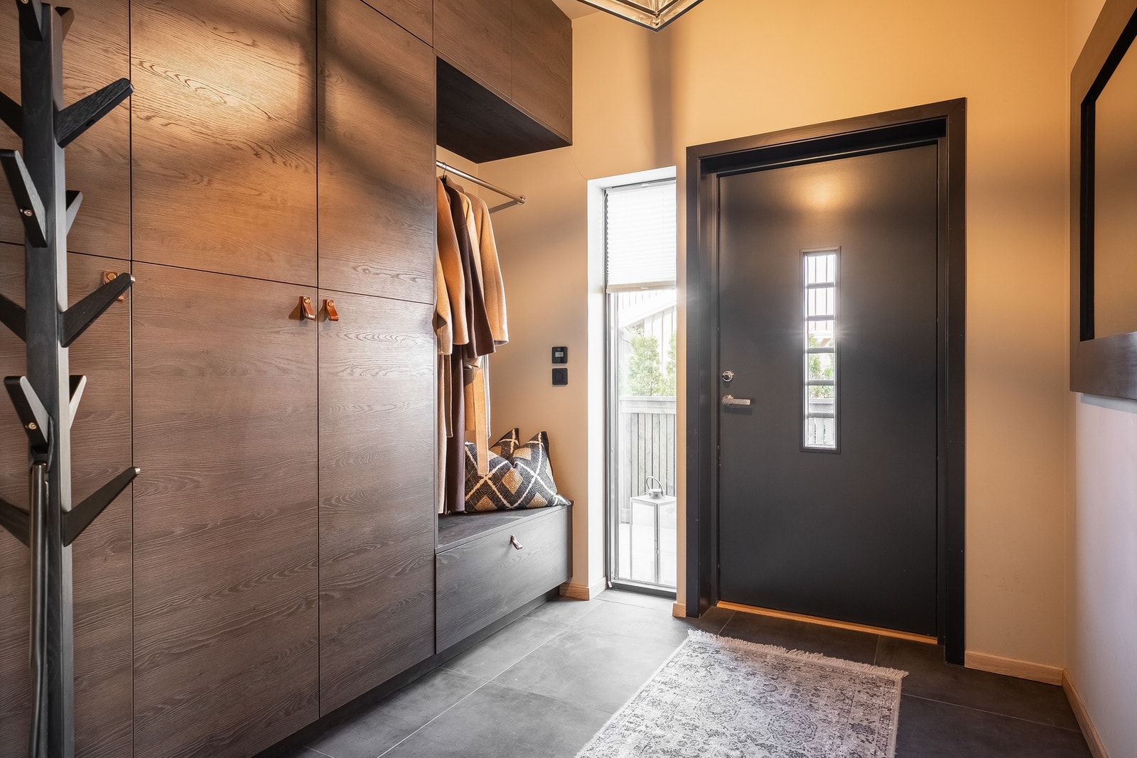 Entreen er elegant og er på 6,5 m² med delikate 60 x 60 fliser på gulv med vannbåren gulvvarme. Fossline garderobeinnredning fra gulv til tak. Galleribilde