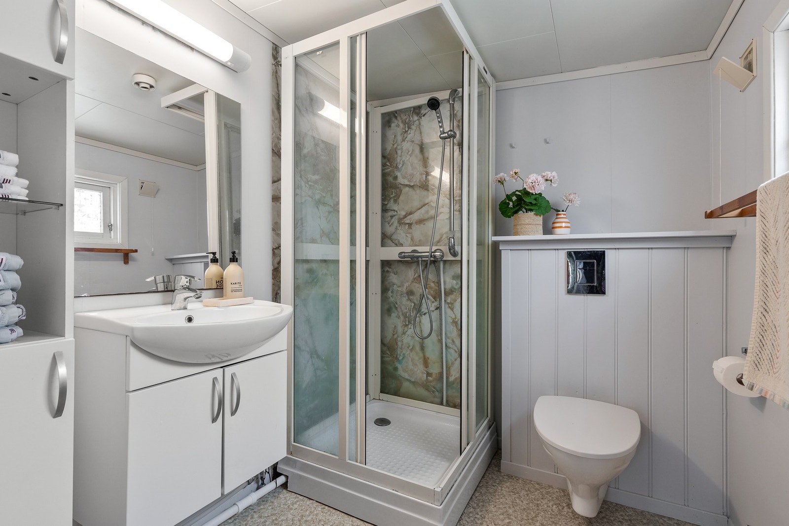 Badet i hovedhytten er innredet med vegghengt servantinnredning, dusjkabinett og et vegghengt toalett Galleribilde