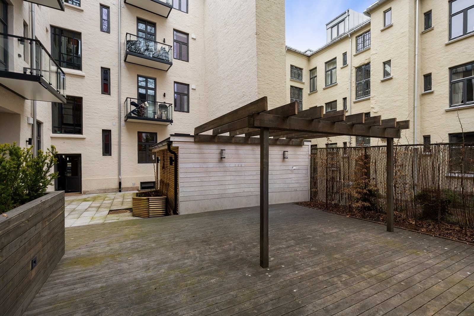 Hyggelig fellesarealer i bakgård med terrasse og beplantning. Det er laget en fellesbod for parkering av barnevogn-/sykkeparkering, samt eget avlukke for avfallshåndtering. Galleribilde