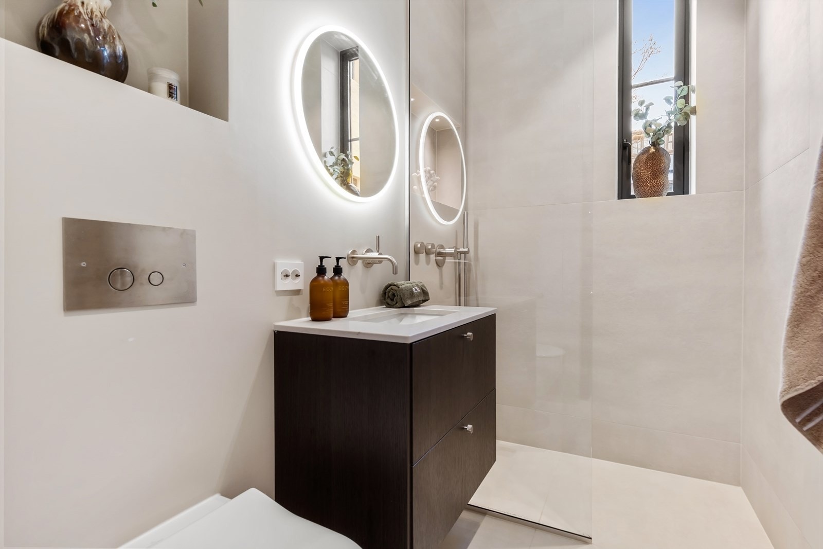 Badet er utstyrt med servant og vegghengt toalett fra Villeroy og Boch, innebygget armatur fra Dornbracht og håndkletørker fra INR. Praktisk dusjsone med regnfallsdusj på badet som gir leiligheten to komplette bad. Galleribilde