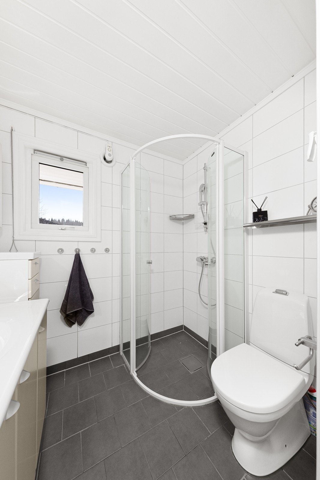 Badet har fliser på veggene, dusjhjørne og toalett. Galleribilde