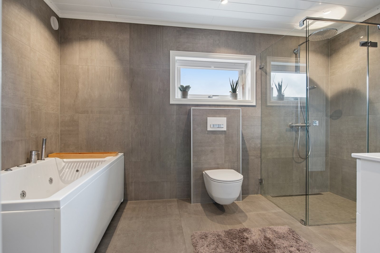 Det helflisede badet fra 2018 er komplett utstyrt med både dusjnisje og badekar. Galleribilde