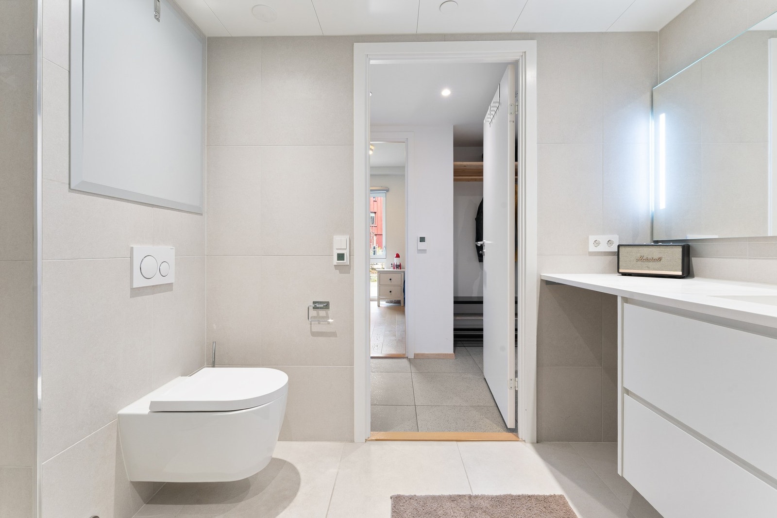 Badet fremstår romslig med moderne innredning og vegghengt toalett Galleribilde