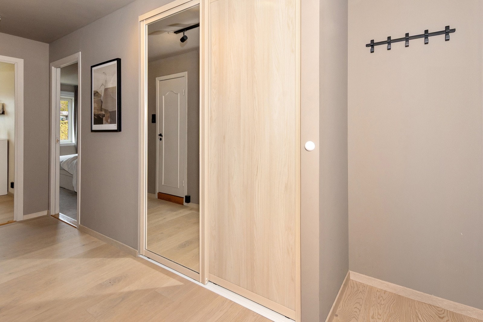 I entreen er det skyvedørsgarderobe med Elfa innredning Galleribilde