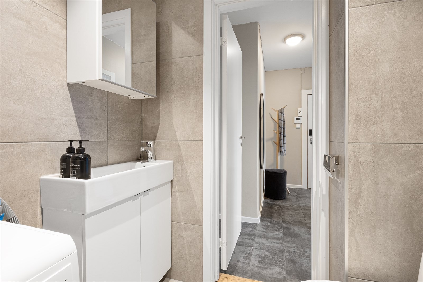 Badet har en praktisk innredning med servantskap og speilskap for oppbevaring. Galleribilde