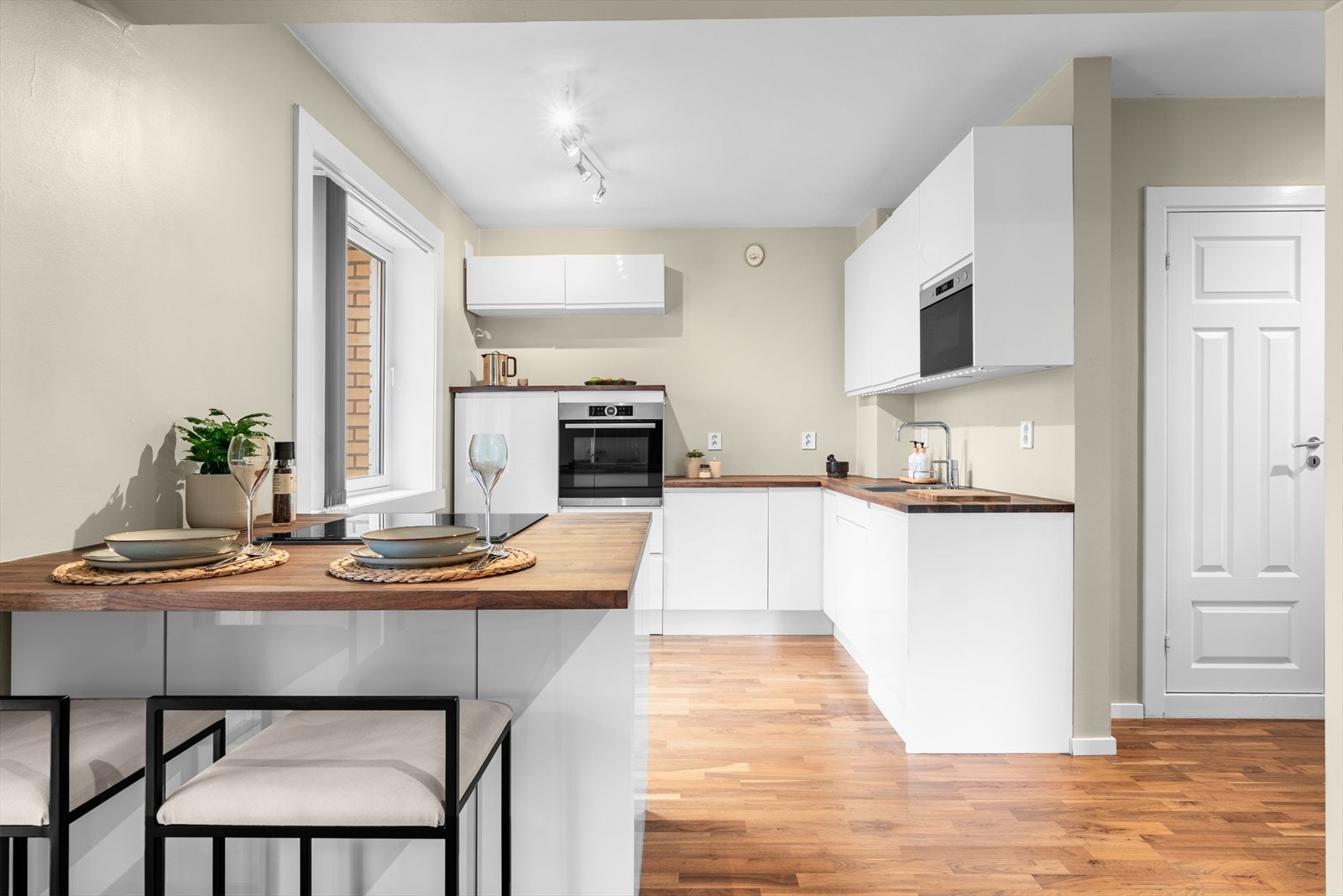 Kjøkkeninnredning fra HTH har høyglansfronter og en solid benkeplate i heltre. Alle hvitevarer medfølger. Galleribilde