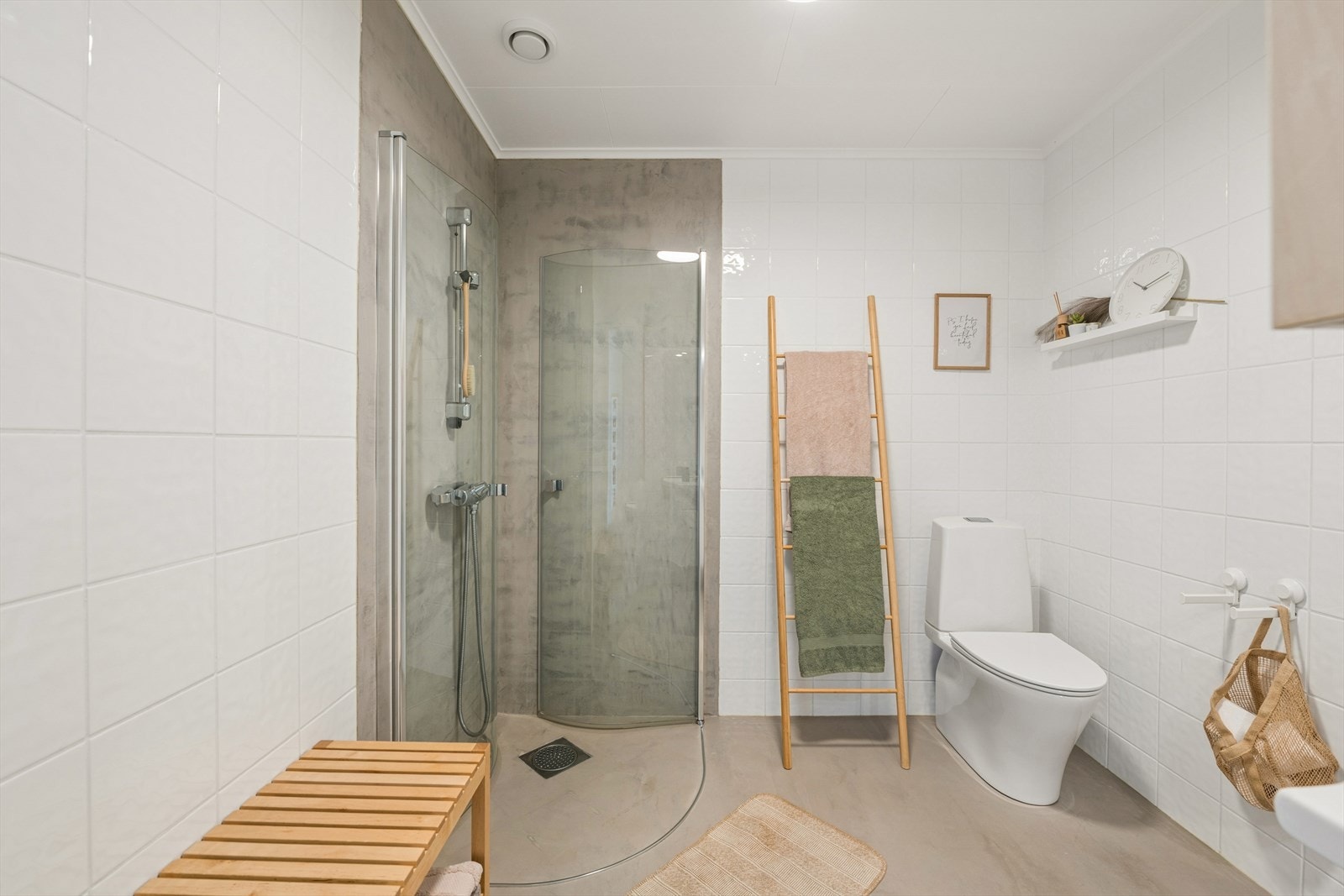 I boligens underetasje finner vi et tidløst, pent og innbydende baderom. Badet er gjennomført med pene fliser på veggene, samt mikrosement på gulvet og veggene i dusjsonen. Galleribilde