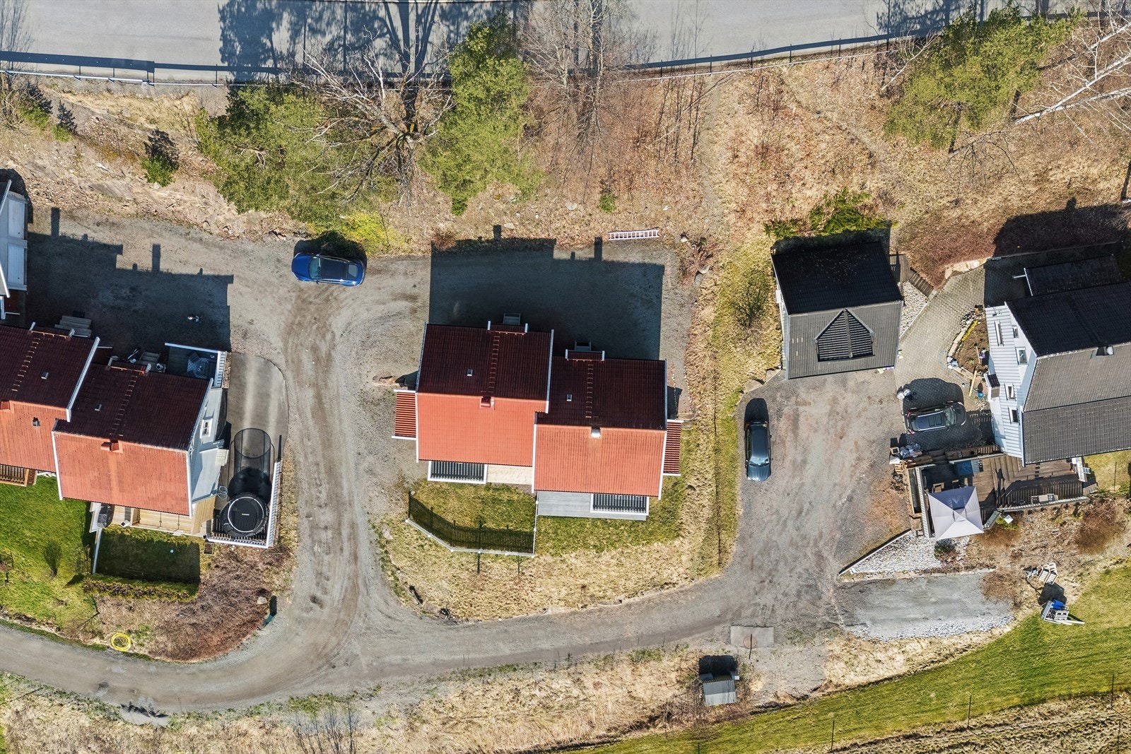 Tomten er opparbeidet med gressplen, beplantning og felles gruset innkjørsel/gårdsplass. Galleribilde
