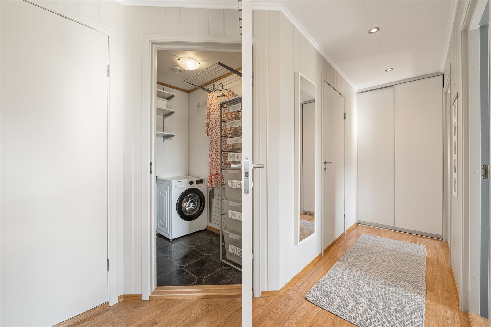 Fordelergangen i underetasjen har praktisk skyvedørsgarderobe for oppbevaring, samt spotbelysning i himling. Galleribilde
