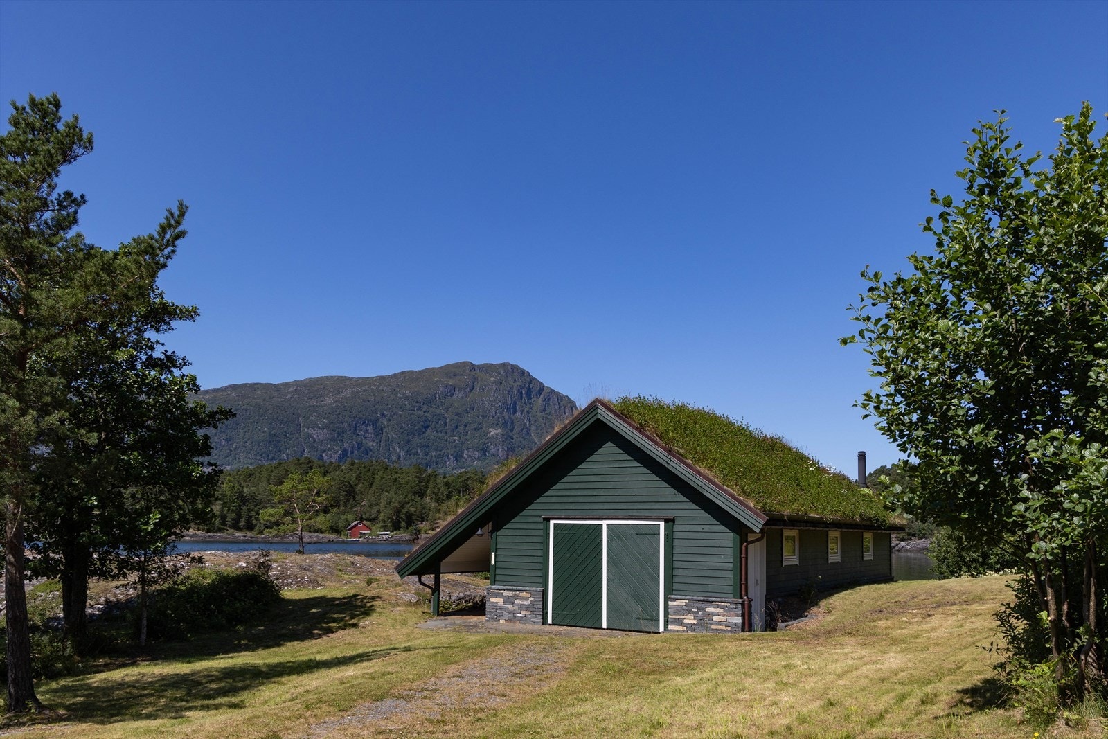 Nede i sjøkanten ligger stort naust med kai og båtslipp, felles for de to hyttene og de fem tomtene. Galleribilde