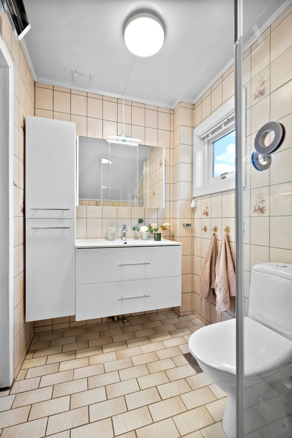 Badet er innredet med dusjnisje, gulvstående toalett og baderomsinnredning. Dusjkabinett er fra 2014, og innredningen ble oppgradert i 2023. Galleribilde