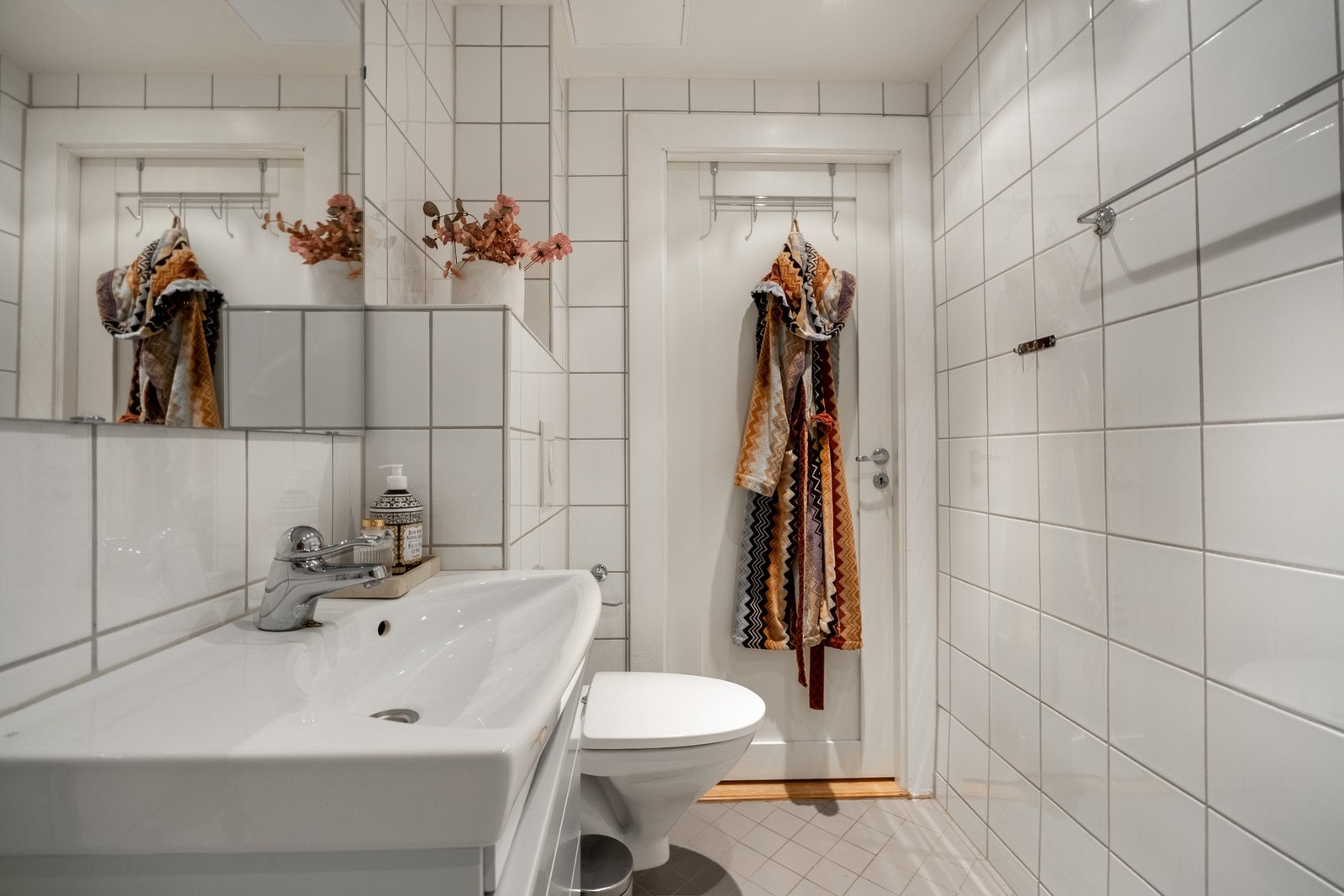 Badet er innredet med vegghengt servantskap med skuff, ovenpåliggende servant, speil og overbelysning, dusjhjørne med innfellbare glassdører og dusjarmatur tilkoblet veggmontert hånddusj, samt vegghengt toalett med innebygget sisterne. Galleribilde