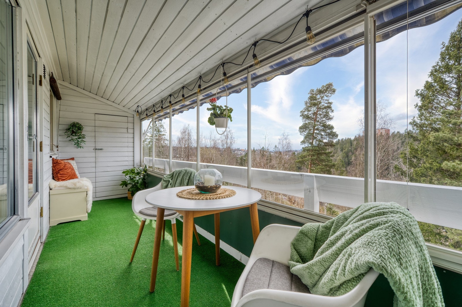 Den innglassede verandaen fungerer som et ekstra oppholdsrom store deler av året, med plass til en hyggelig sittegruppe. Galleribilde