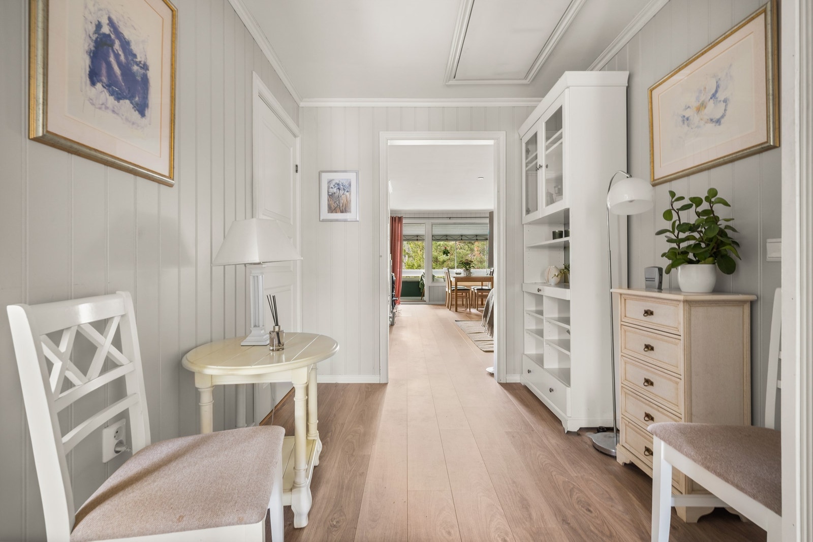 Fra entréen leder en gang deg videre inn i leiligheten. Gjennomgående laminatgulv i de fleste oppholdsrom. Galleribilde