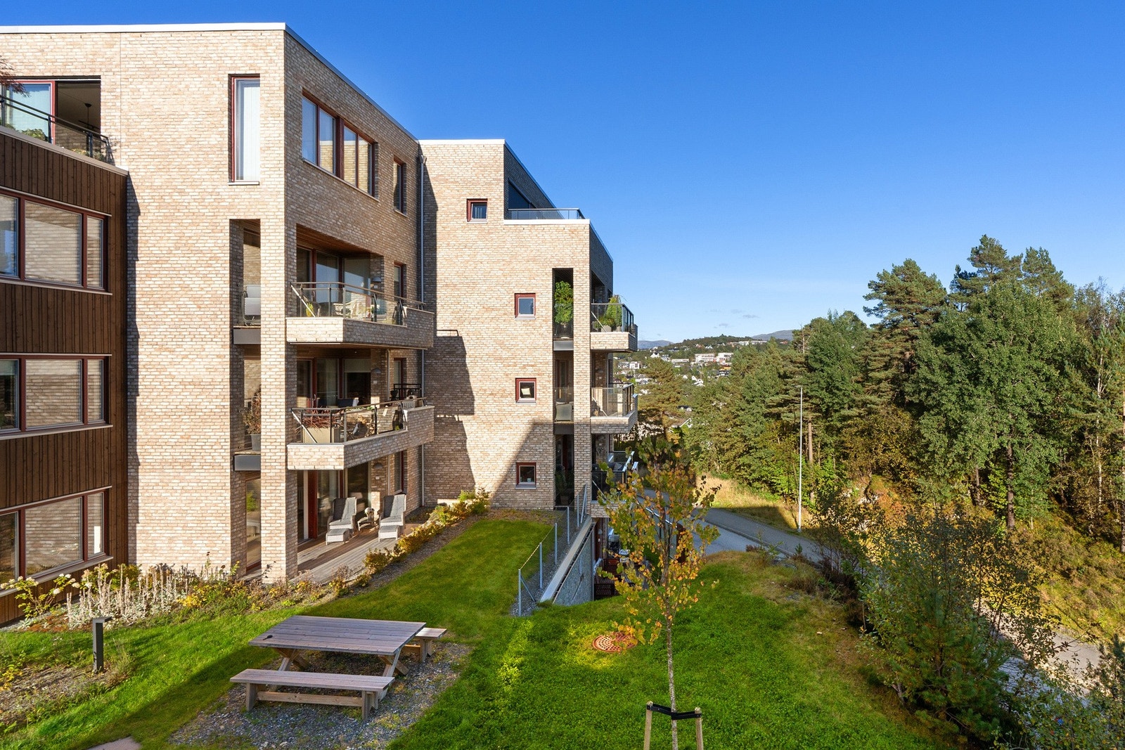 Uteområdet er opparbeidet med belegningsstein, gress og lekestativer. Galleribilde