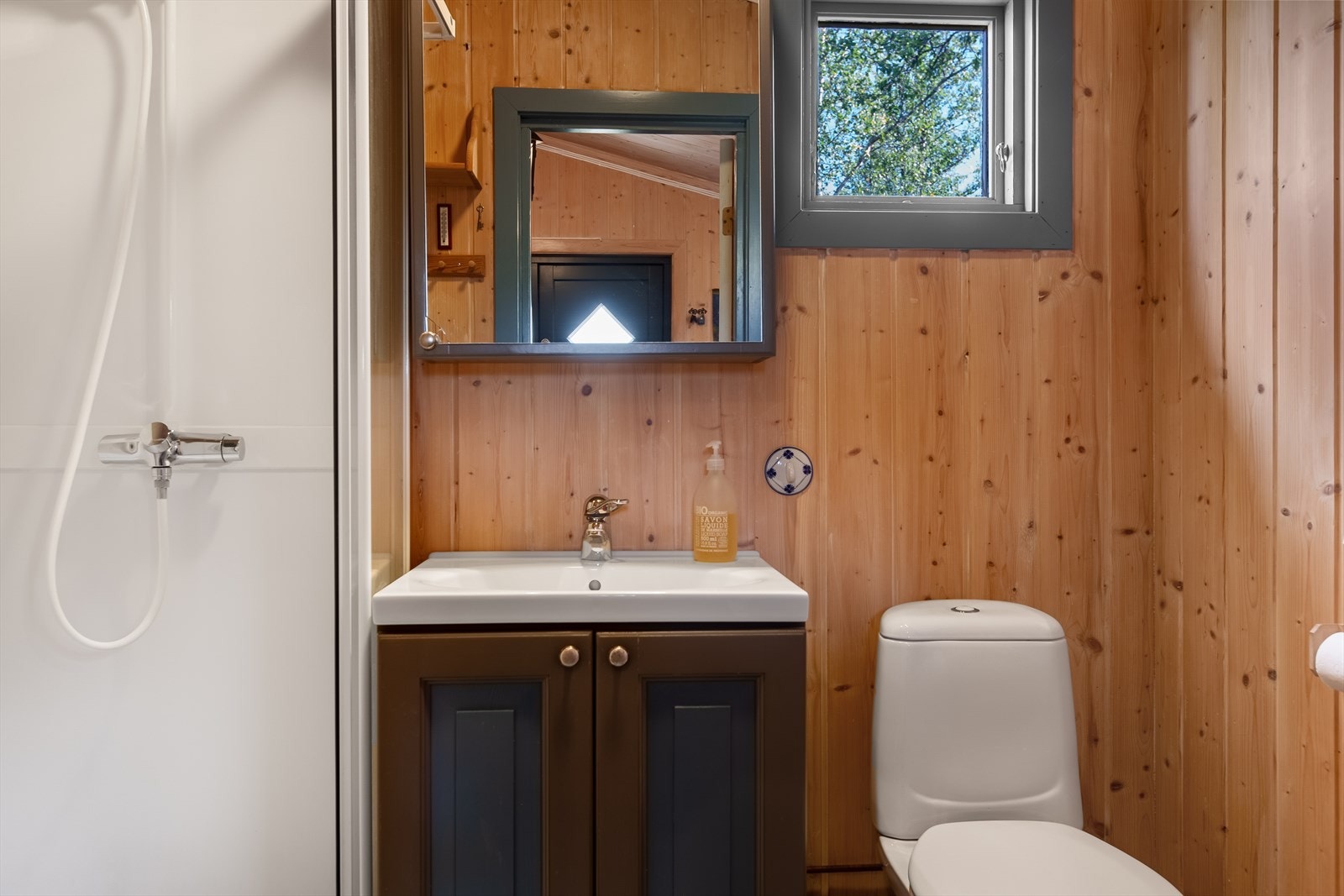 Badet har vinylbelegg med varmekabler, dusjkabinett og en prakstik innredning med oppbevaringsplass i underskap. Galleribilde