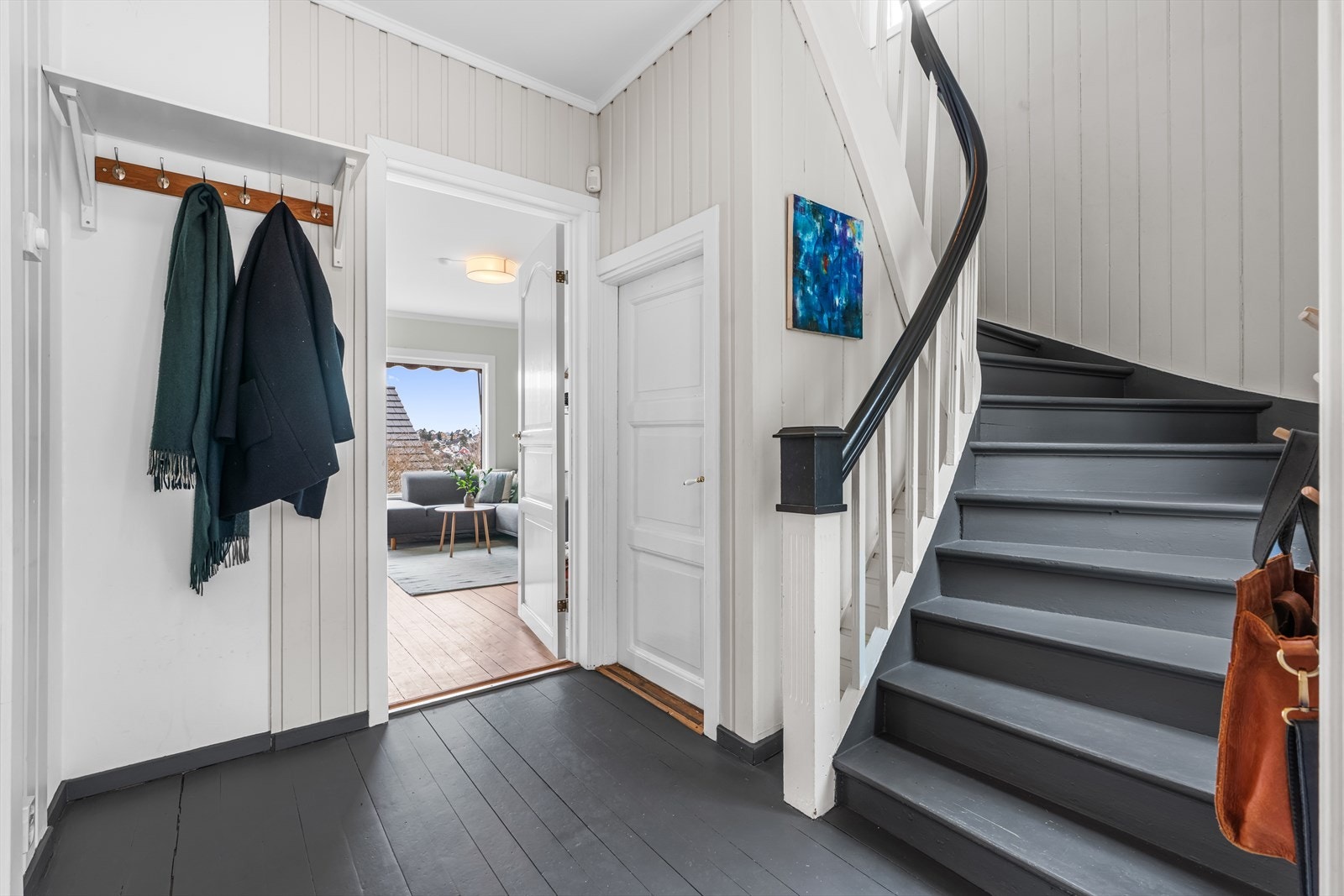 Entréen har malte panelvegger og en sjarmerende trapp som binder etasjene sammen. De fleste overflater er malt i 2024. Galleribilde