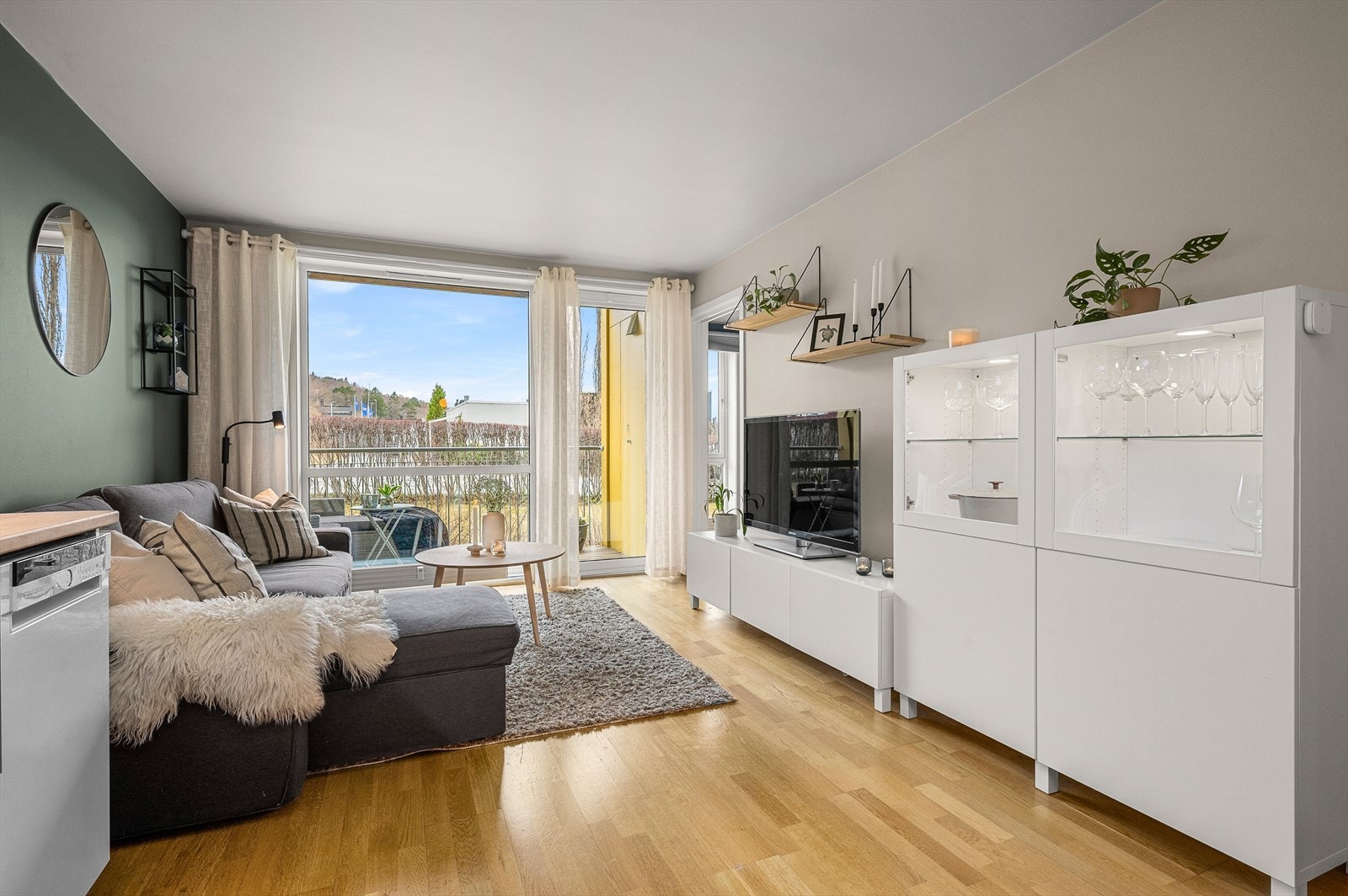 Tilbake inne oppleves stuen som romslig og funksjonell med naturlige soner for både sofa og spiseplass. Galleribilde