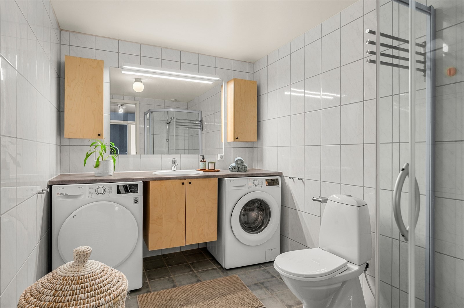 Badet er flislagt og måler ca. 6 m² med varmekabler og praktiske løsninger. Galleribilde