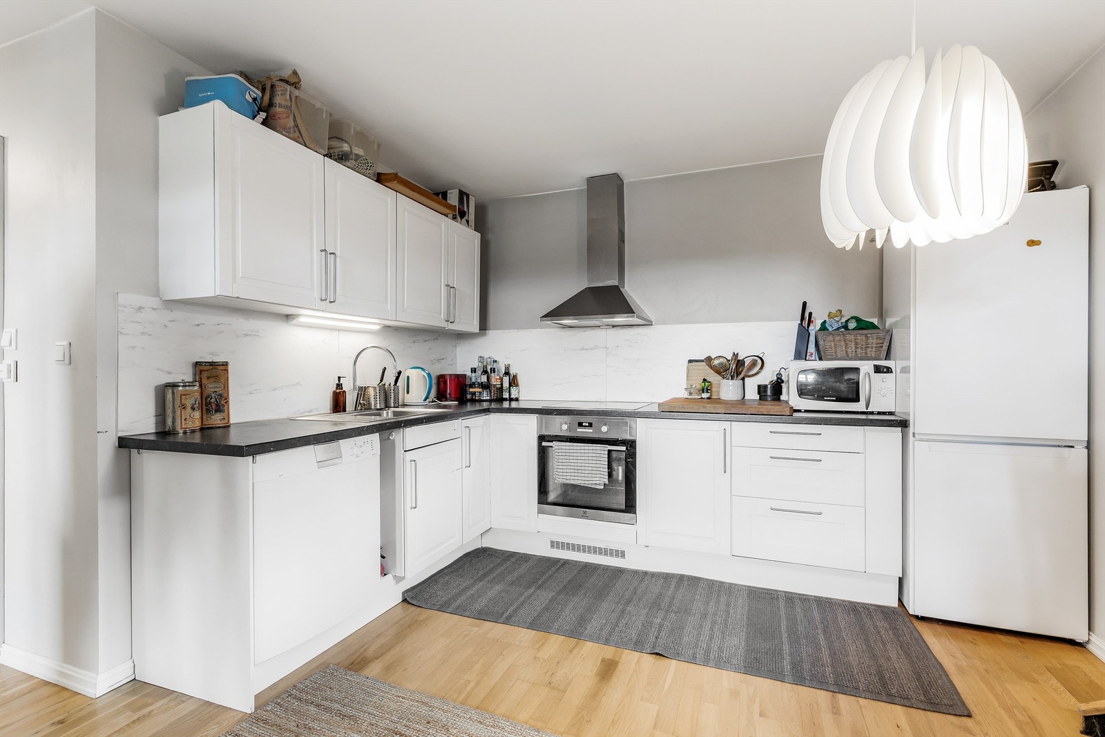 Hybel: Åpen kjøkkenløsning. Innredning fra byggeår. Profilerte fronter. Benkeplate med laminert overflate. Nedfelt kjøkkenvask med armatur. Benkeskapsbelysning og stikkontakter over kjøkkenbenk. Integrert stekeovn og platetopp. Galleribilde