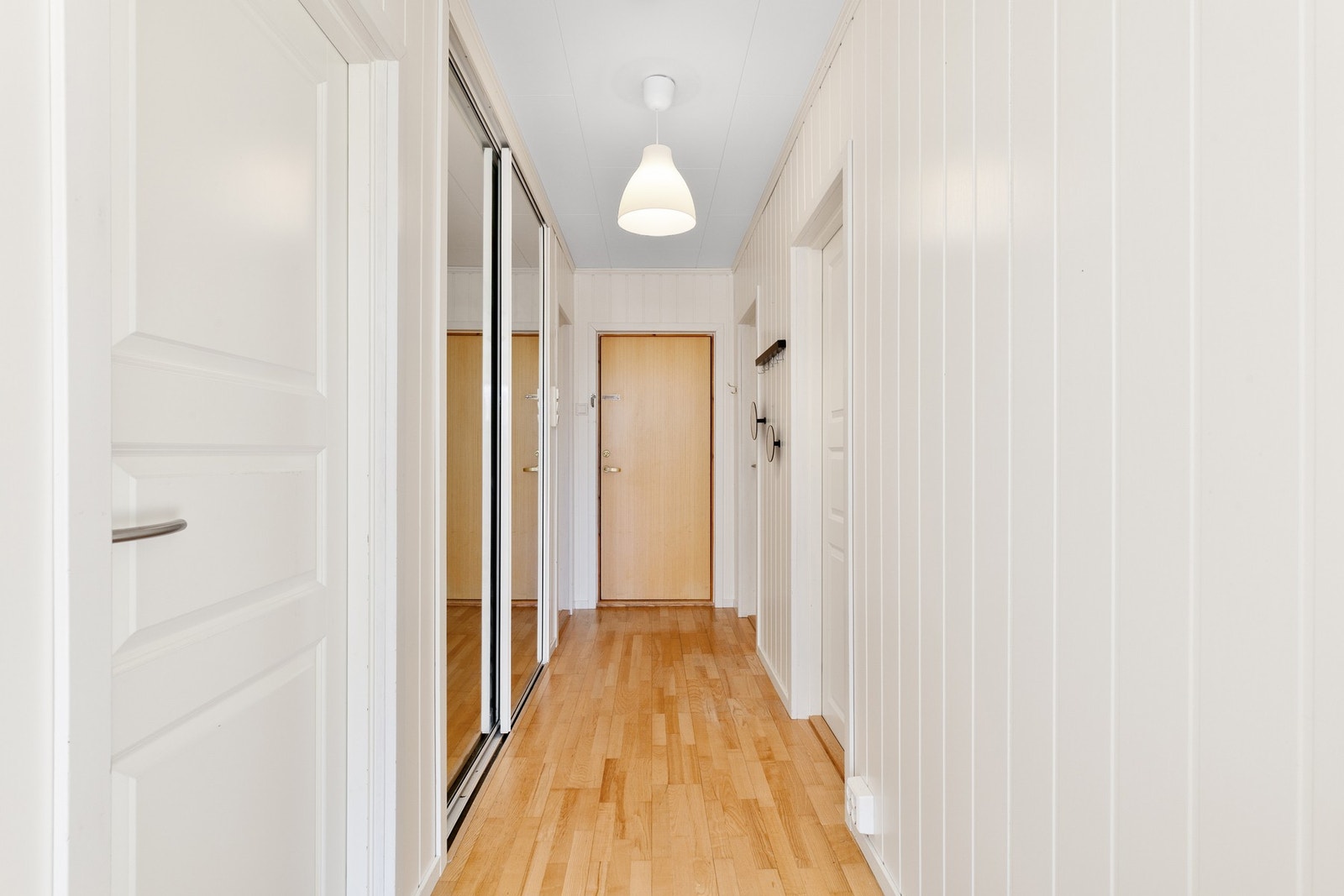 Lys og innbydende entrè med skyvedørsgarderobe. Galleribilde